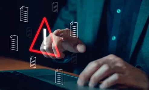 Person's hand touching a glowing red warning triangle surrounded by floating document icons
