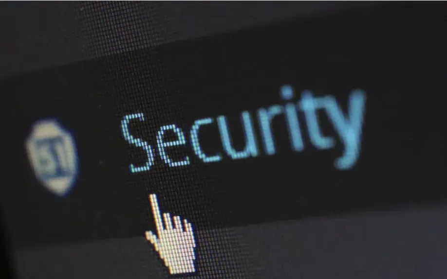 Close-up of a screen with the word Security and a cursor hand pointing at a shield icon