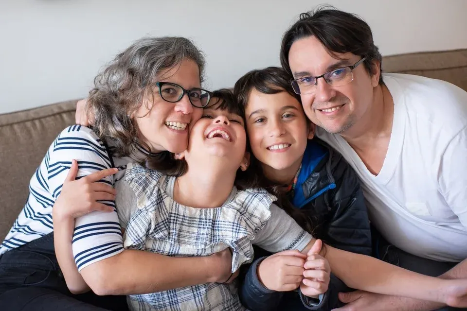 Parents and children sharing a happy embrace at home.